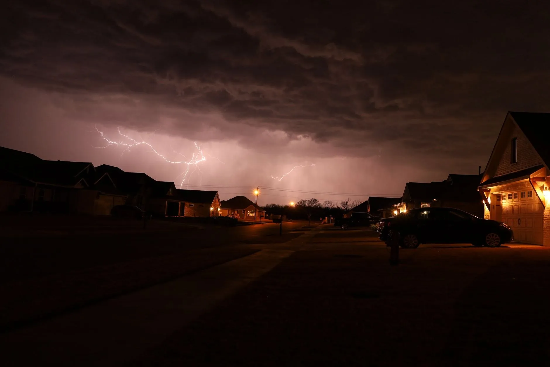 Lightning over a row of suburban houses at dusk